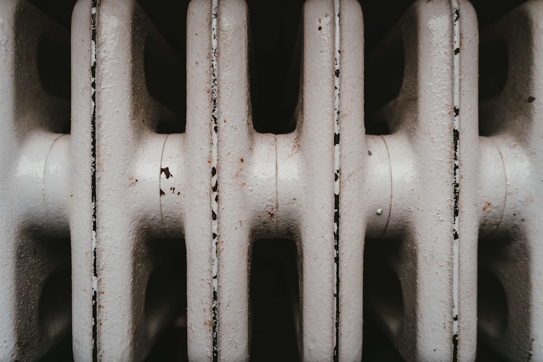 Close-up of a white cast iron radiator with visible rust and wear.